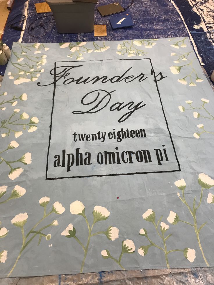 the table is covered with fabric and flowers on it, which has been made into a family's day sign