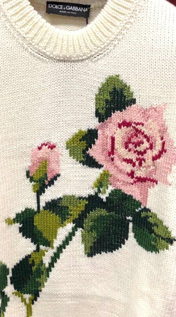 a white sweater with pink roses on it