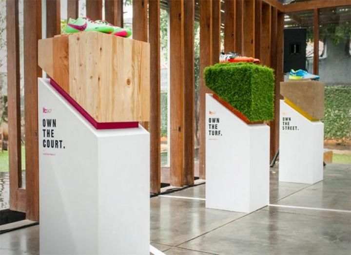 three white boxes with grass in them sitting on the floor next to some wood planks