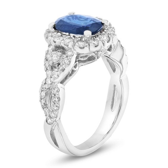 An extraordinary treat for an extra-special someone, this gemstone and diamond ring is designed to sparkle for a lifetime. Dazzling in cool 14K white gold, this timeless treasure showcases a 9.0 x 7.0mm oval-shaped bright blue sapphire wrapped in a glittering frame of round diamonds. An accent diamond on either side of the center stone captures her attention further, while smaller diamonds along the sculpted twist shank complete the look. More than she can imagine, this gorgeous ring boasts 3/4 cts. t.w. of diamonds and a brilliant buffed luster. Diamond Infinity Ring, Infinity Diamond Ring, Split Shank Engagement Rings, Diamond Frame, Sapphire And Diamond Ring, Sapphire Engagement Ring Blue, Infinity Ring, Blue Sapphire Diamond, Engagement Rings Sapphire