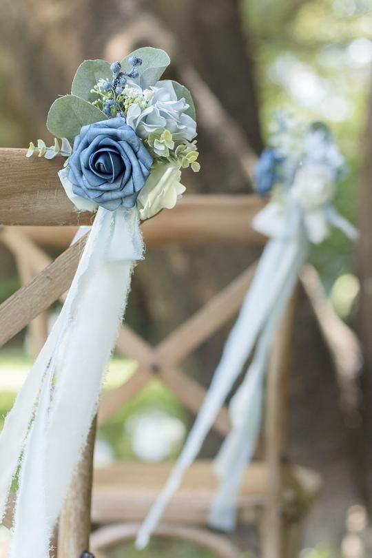 blue and white flowers are tied to the back of a chair with ribbons on it