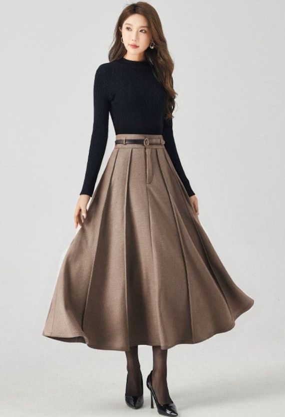 Discover modern elegance in our brown pleated high-waisted wool midi skirt. The versatile brown shade effortlessly complements various tops, and the premium wool fabric guarantees both coziness and luxury. DETAIL * 30% wool, 30% fiber, 40% polyester * fully satiny liner * Two side pockets * Front zipper closure * Has belt loops to keep everything in place * Pleated skirt * Perfect for Winter, autumn * Learn More about the items From the FAQs on the page bottom MODEL SIZE Bust 85 cm(33.4") Waist 67 cm(26.7") Height 168cm (5' 6") She wears size XS CUSTOM MADE SERVICE If you * Change other color * Can't find your size in our size Chart * Change the Style * Change the length * Your Height is not Between 5'1" - 5"9" * Your weight is not Between 47 kg - 75kg I can do it for you, It will need som