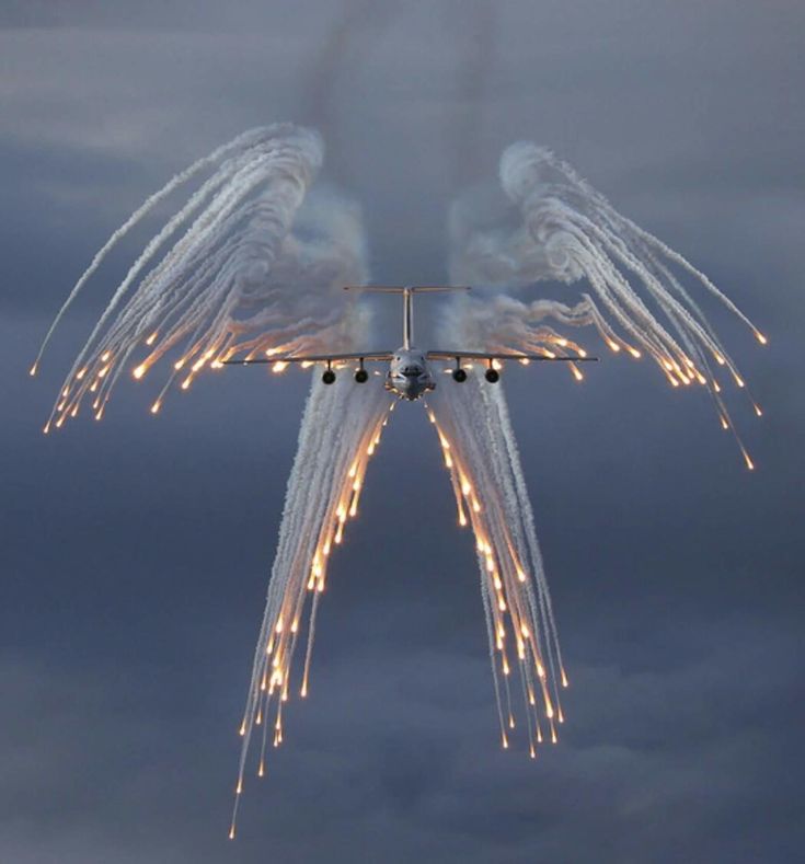 an airplane is flying through the air with its wings spread out and lights on it