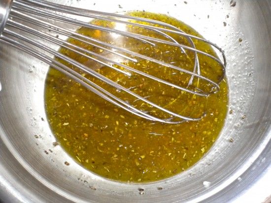 a metal bowl filled with green liquid and whisk