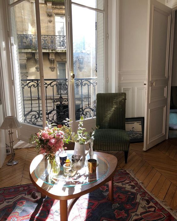 a living room filled with furniture and a large window covered in glass door frames next to a balcony