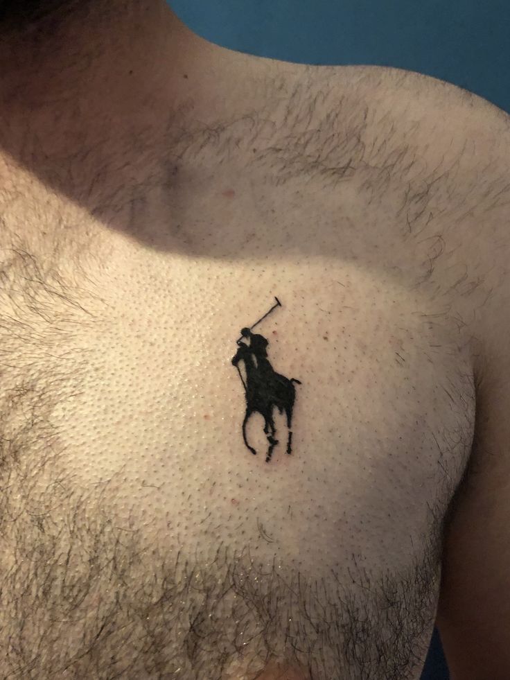 a man's chest with a small tattoo of a horse and rider on it