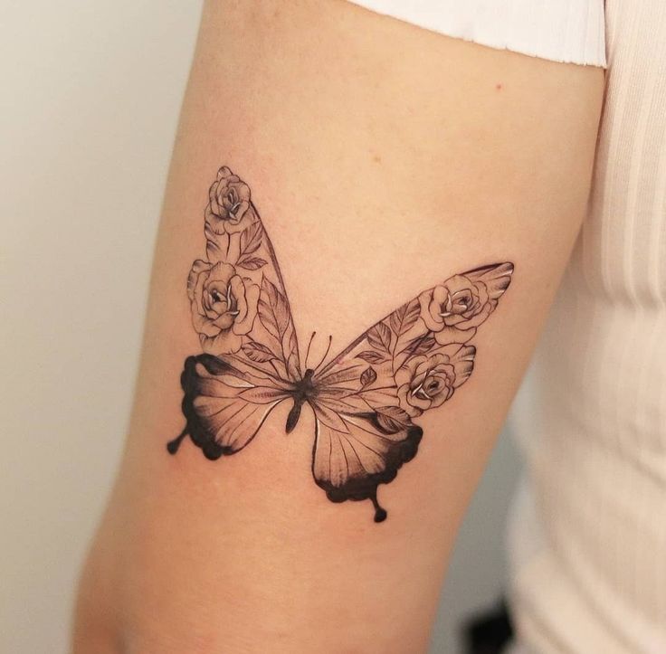 a woman's arm with a black and white butterfly tattoo on the left side