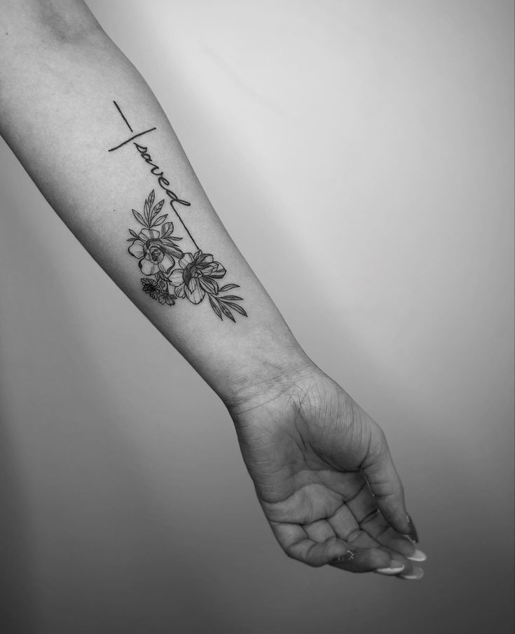 a black and white photo of a person's arm with a flower tattoo on it