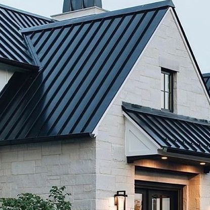 a white brick house with black metal roofing