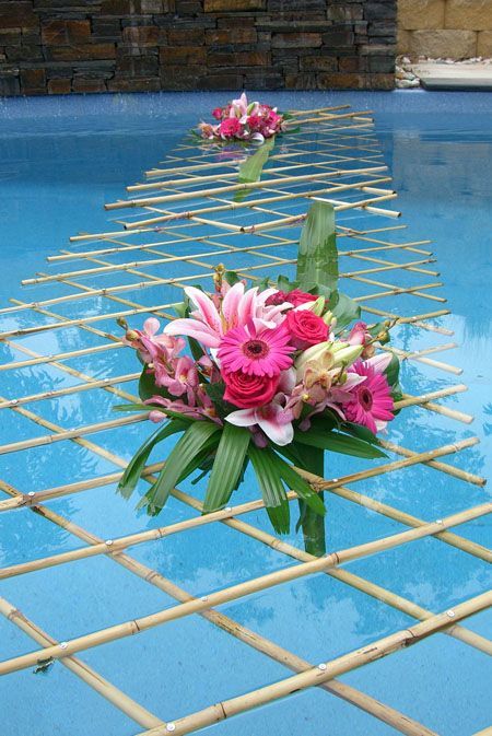 flowers are placed on the edge of a swimming pool