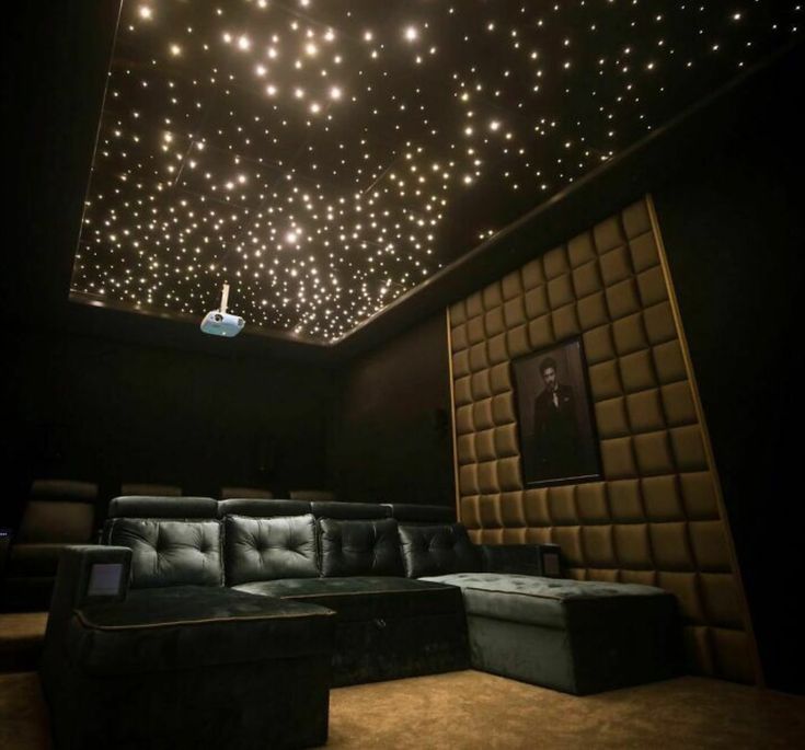 the ceiling is covered with stars and lights in this home theater room, which also has leather couches