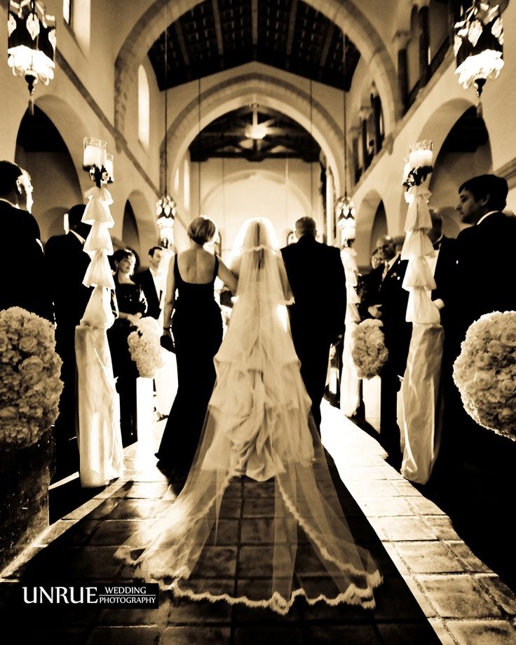 a bride and groom walking down the aisle