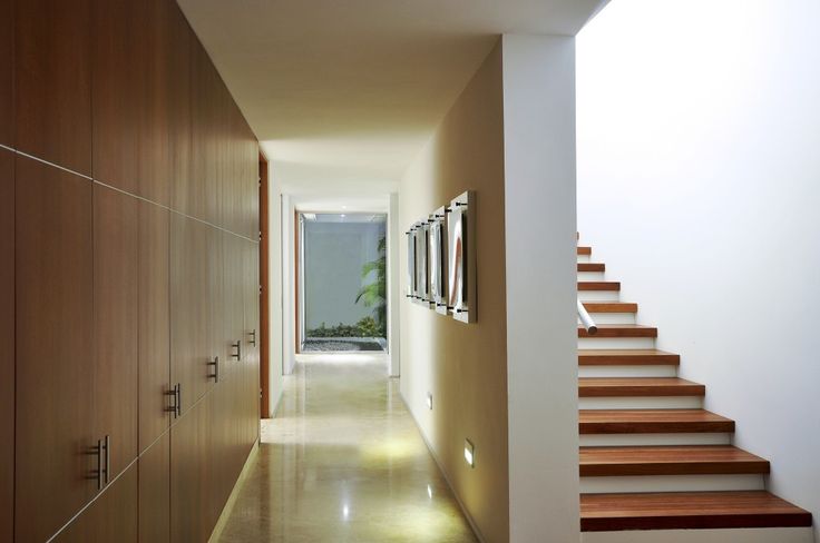 an empty hallway with wooden steps leading to the upper floor