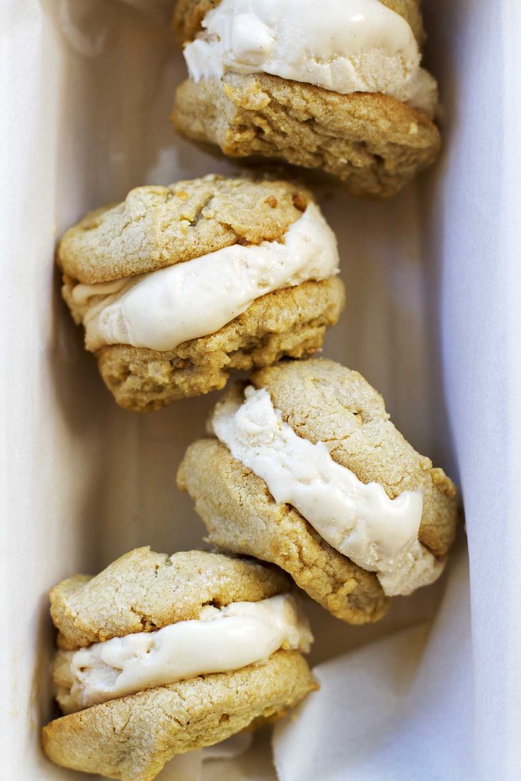 three cookies with icing in a white container