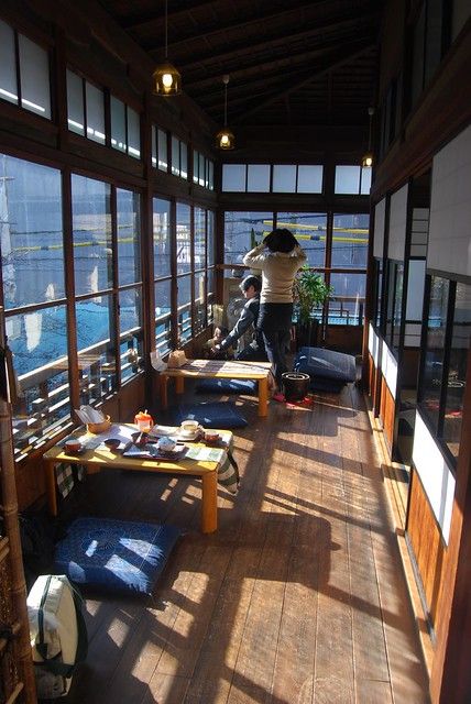 a man standing on top of a wooden floor next to lots of windows in a building