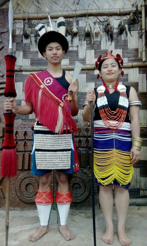 two people standing next to each other in front of a wall with decorations on it