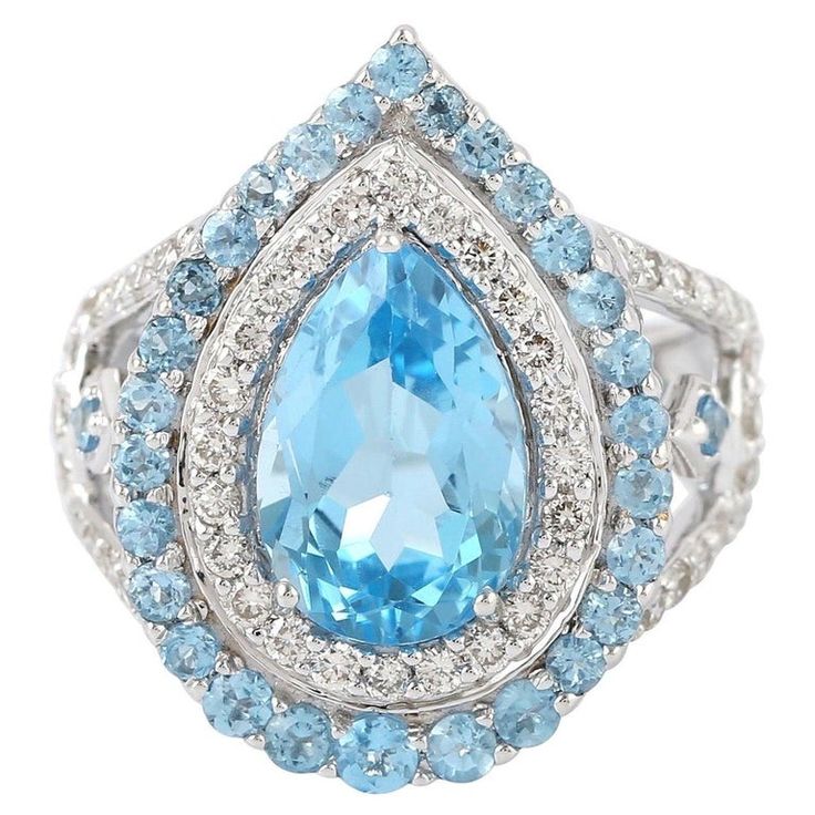 This stunning ring has been meticulously crafted from 18-karat gold. It is hand set in 5.43 carats blue topaz and illuminated with .91 carats of glittering diamonds. The ring is a size 7 and may be resized to larger or smaller upon request. FOLLOW MEGHNA JEWELS storefront to view the latest collection & exclusive pieces. Meghna Jewels is proudly rated as a Top Seller on 1stDibs with 5 star customer reviews. All items manufactured by us are handmade and can be customized or redesigned. Compos Luxury Hallmarked Collectible Topaz Ring, Teardrop Engagement Ring, Argentium Silver Jewelry, Diamond Glitter, Diamond Cocktail Rings, Luxury Rings, Modern Ring, Swiss Blue Topaz, Split Shank