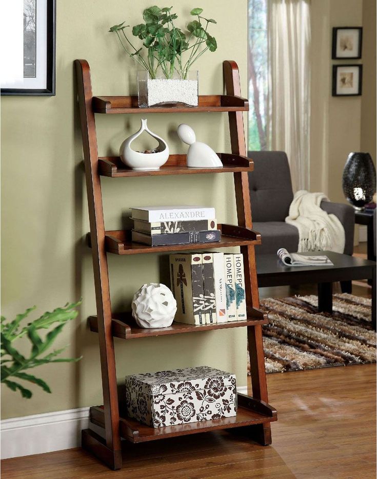 a wooden shelf with books and vases sitting on top of it in a living room