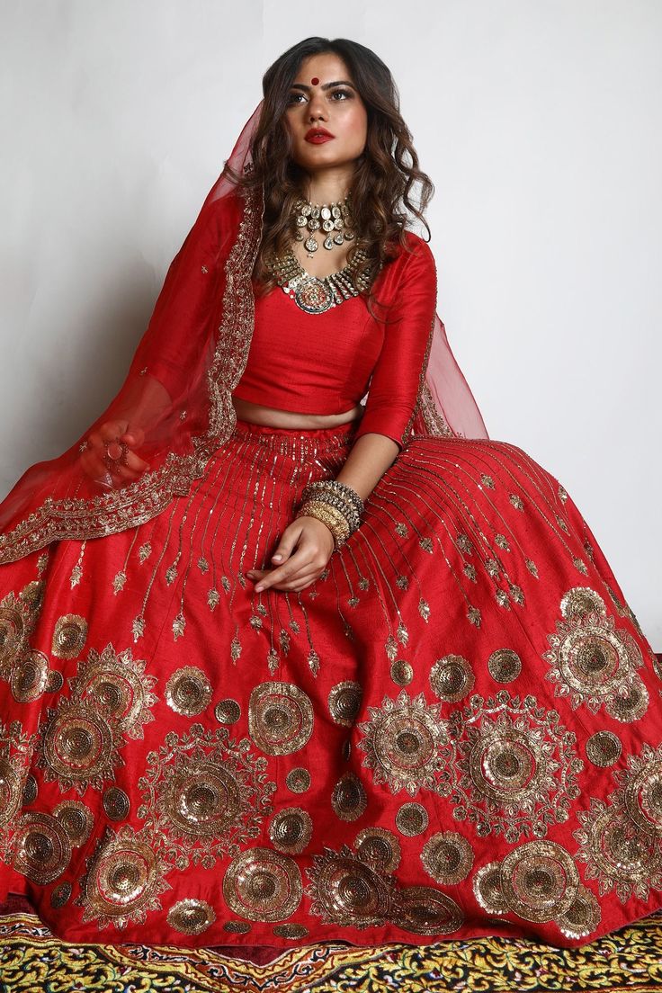 Red dupion silk lehenga with zari and sequins hand embroidered chakra motifs. Comes with a padded blouse and an organza scalloped dupatta.
Component: 3
Pattern: Embroidered
Type Of Work: Zari, Sequins
Neckline: V Neck
Sleeve Type: Three quarter
Fabric: Lehenga and Blouse: Dupion Silk, Dupatta : Organza 
Color: Red
Other Details: 
Closure : Blouse : Back with Hook and Eye, Lehenga : Opening on the side with Zip and Hook along with Drawstring.
Occasion: Wedding - Aza Fashions Zari Lehenga, Scalloped Dupatta, Lehenga And Blouse, Padded Blouse, Red Lehenga, Embroidered Lehenga, Blouse Back, Lehenga Blouse, Dupion Silk