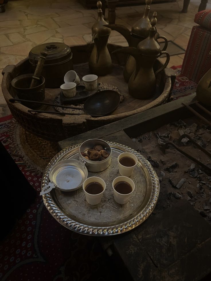 there is a tray with cups on it in the middle of a room filled with pottery