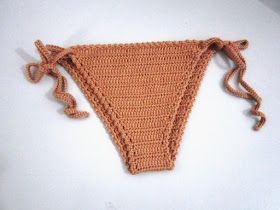 an orange crocheted triangle is shown on a white surface