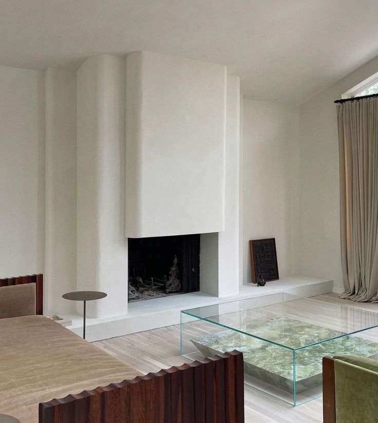 a living room filled with furniture and a fire place next to a glass coffee table