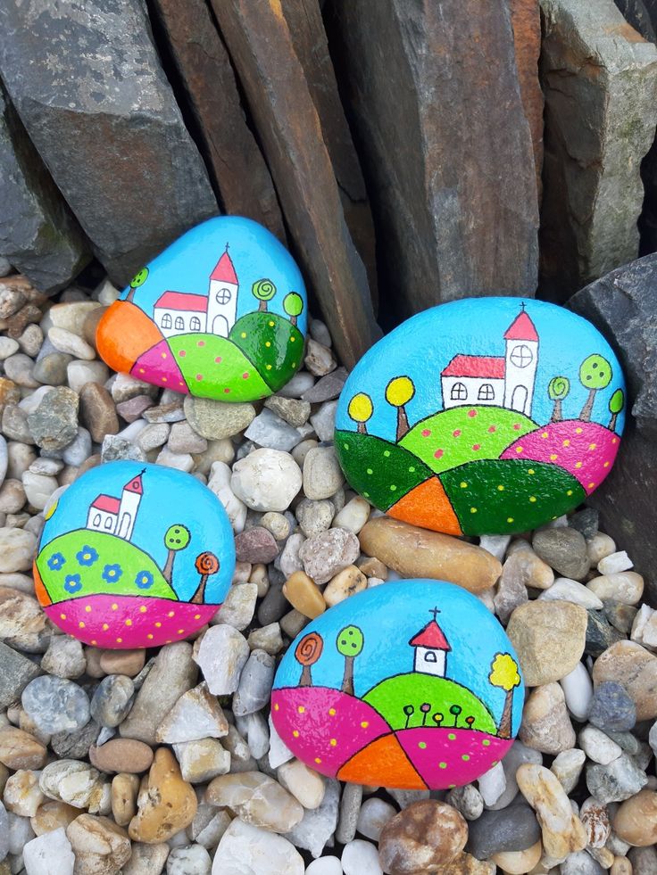 three painted rocks sitting on top of some rocks