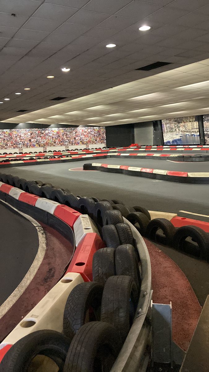 an empty race track with lots of tires on the sides and rows of seats to the side