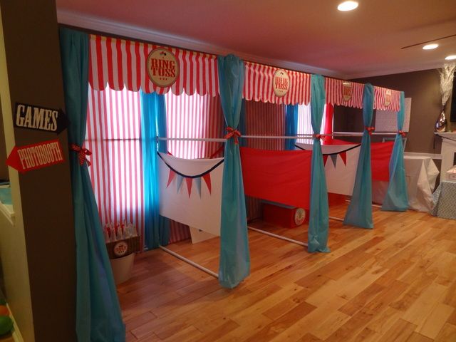 a room that has some curtains on the wall and red and blue drapes hanging from the ceiling