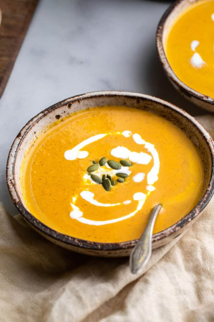 two bowls filled with soup on top of a table