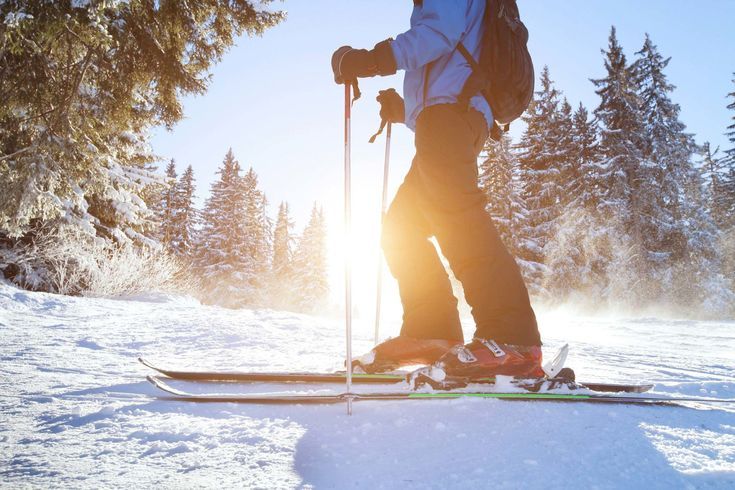 a person standing on skis in the snow with trees in the backgroud