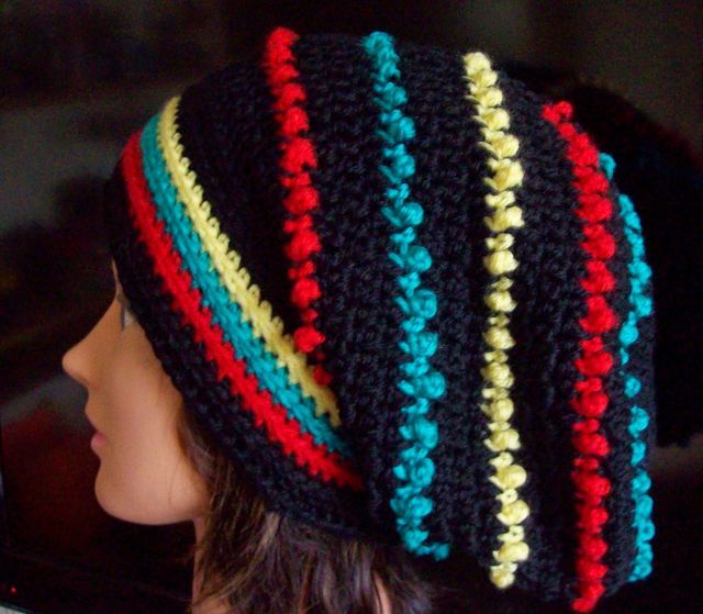 a woman wearing a multicolored crocheted hat on top of her head