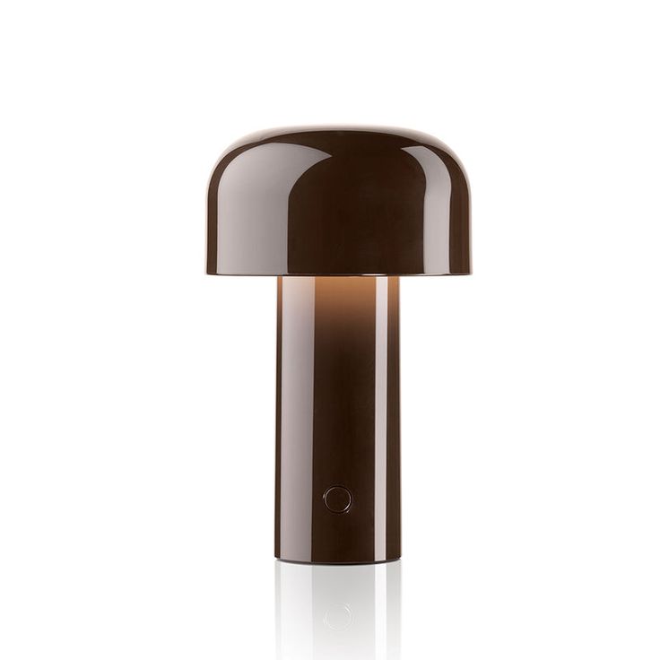 a brown table lamp on a white surface with a black base and light bulb at the top