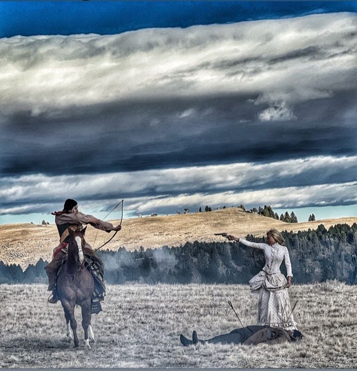 two people on horses in the middle of a field with trees and clouds behind them