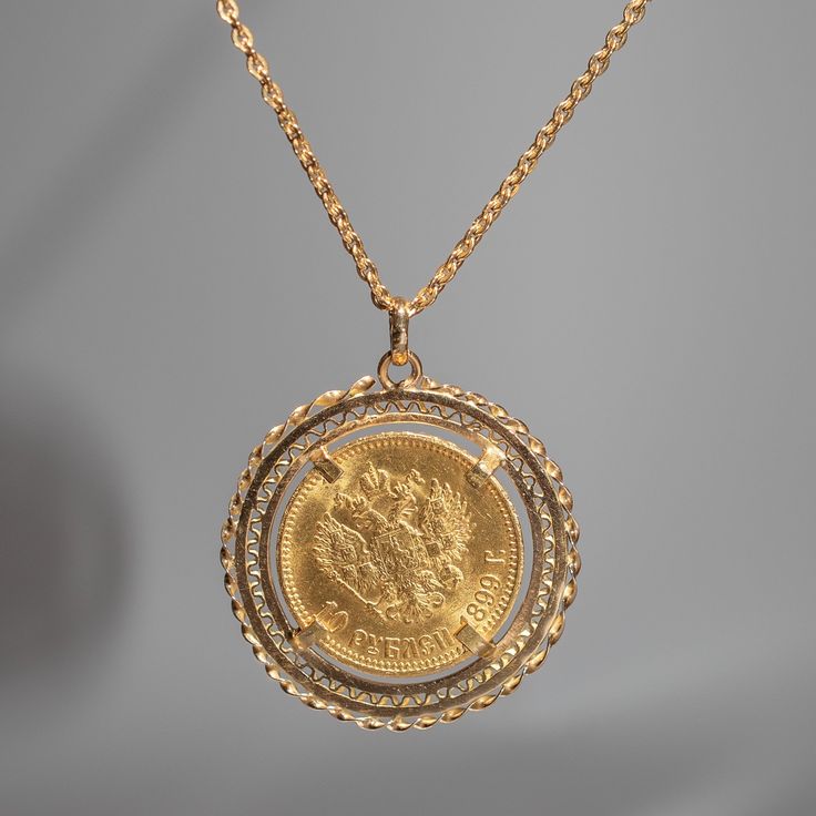 This pendant features a 1899 10 Roubles Russian Empire solid 14k yellow gold coin that displays Tsar Nicholas II in a 14k yellow gold setting. Materials: 14k yellow gold Pendant Size: 38.5mm from bottom of pendant to top of bail Comes with a 32 inch 14k yellow gold cable chain Tsar Nicholas II, the last Emperor of Russia, reigned from 1894 until his abduction in 1917. The coin of Nicholas II feature his portrait on the obverse, displaying his likeness in intricate detail. The reverse side showca Russian Necklace, Russian Coat, The Last Emperor, Empire Logo, Russian Jewelry, Last Emperor, Double Headed Eagle, Russian Revolution, Russian Empire