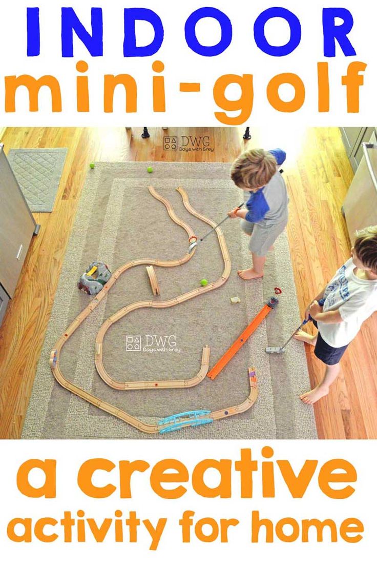 two children playing with a toy train set on the floor