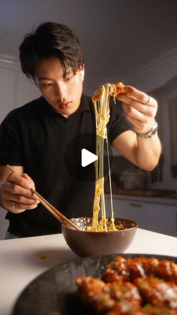 a man is eating spaghetti with chopsticks