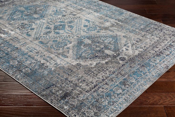 a blue and white rug with an intricate design on the top, sitting on a wooden floor