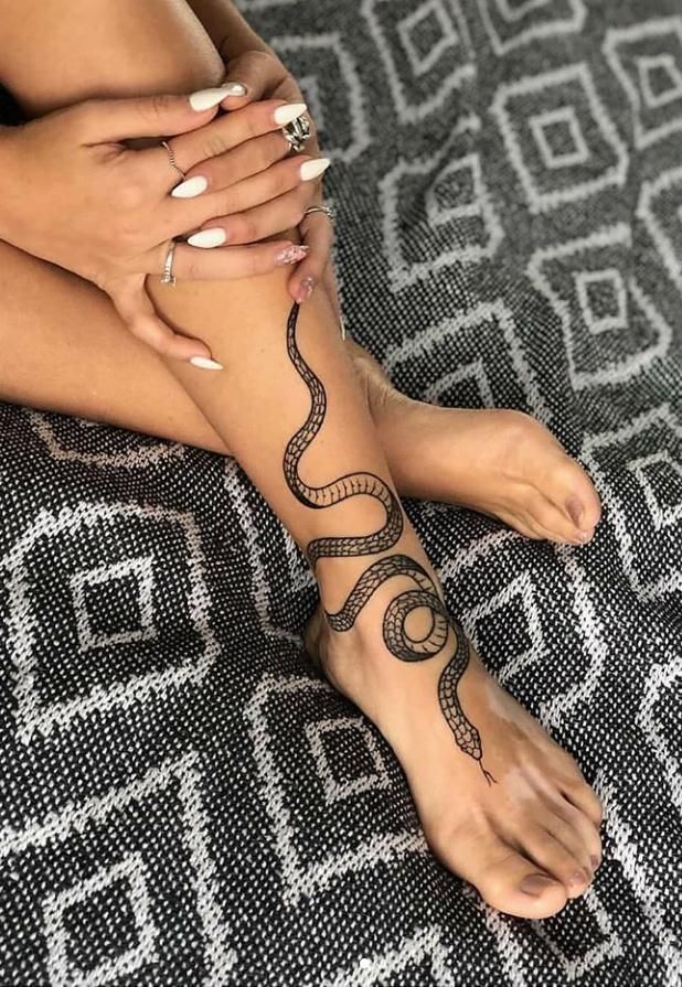 a woman's foot with a snake tattoo on her leg and the caption below reads, see more posts like this