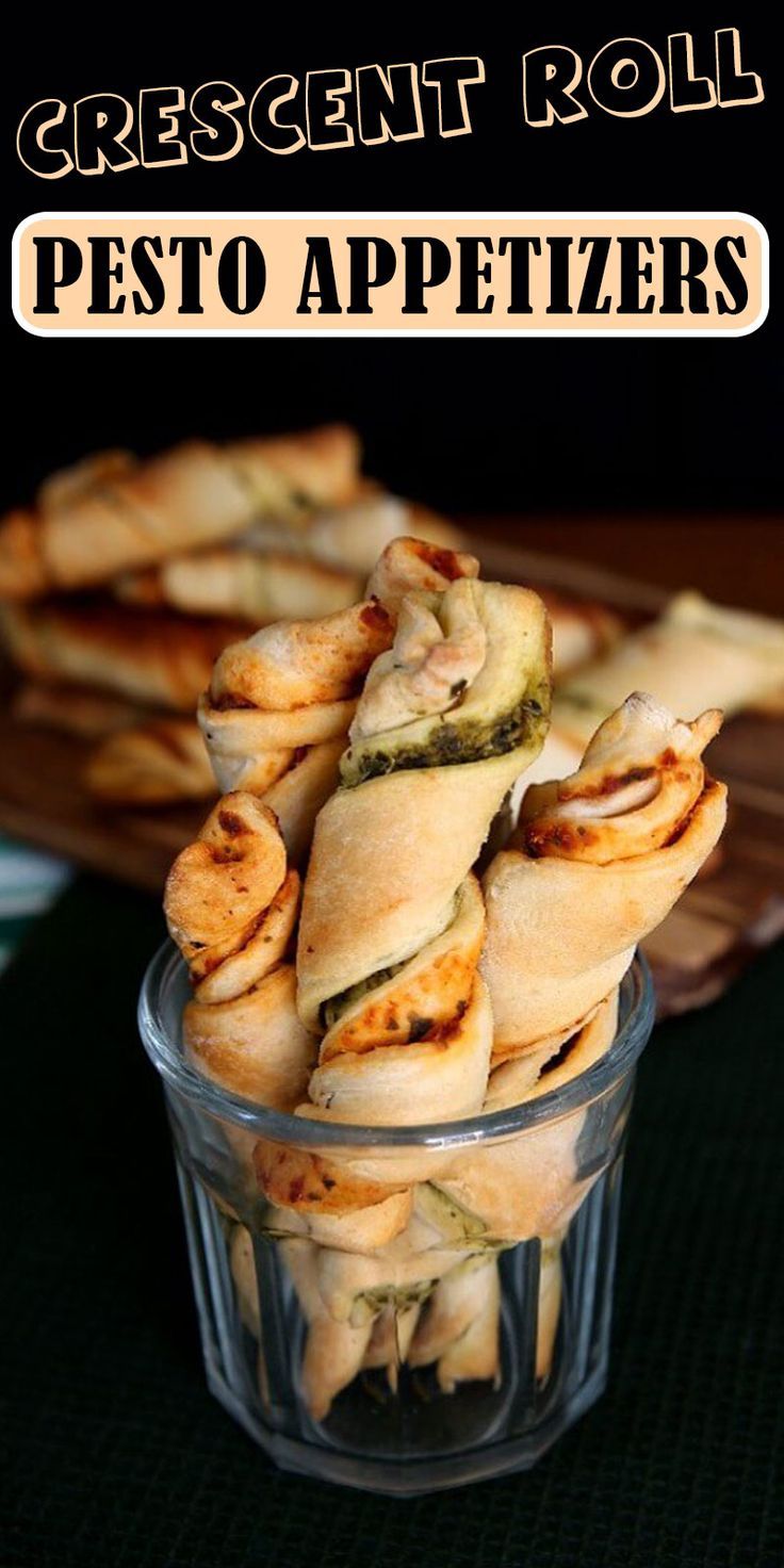 some food is in a glass bowl on a table with the words crescent roll pesto appetizers