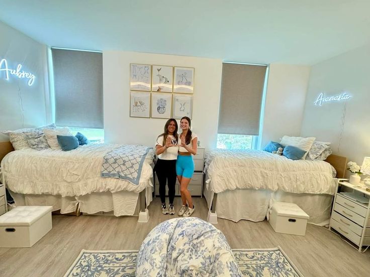 two women are standing in the middle of a bedroom