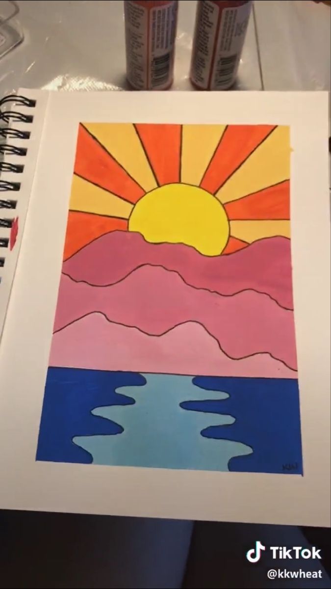 a drawing of the sun setting over water with two cans of soda in front of it