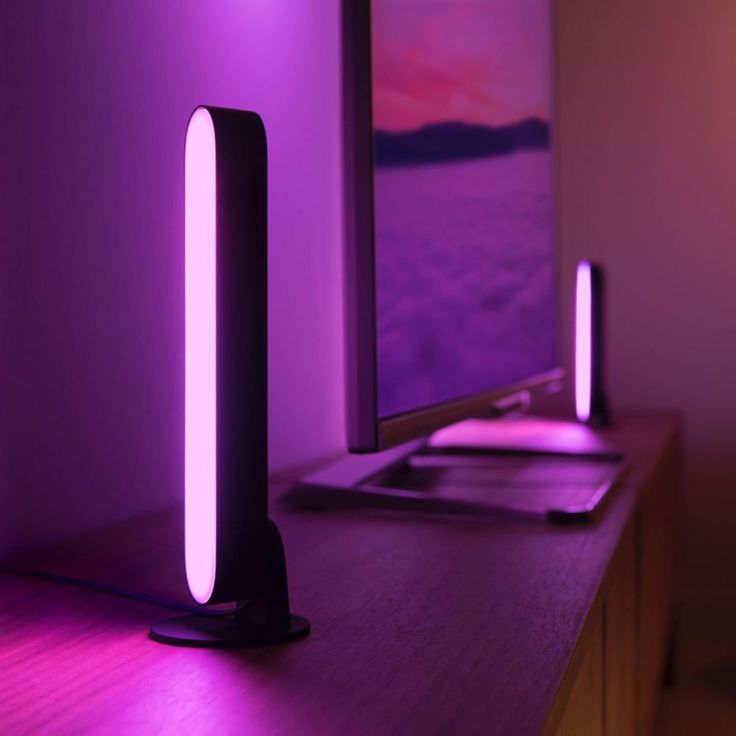 a desk lamp sitting on top of a wooden table next to a computer monitor and keyboard