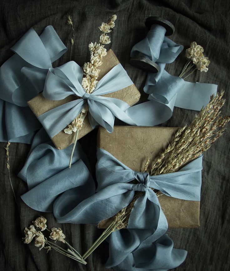 wrapped presents with blue ribbons and dried flowers