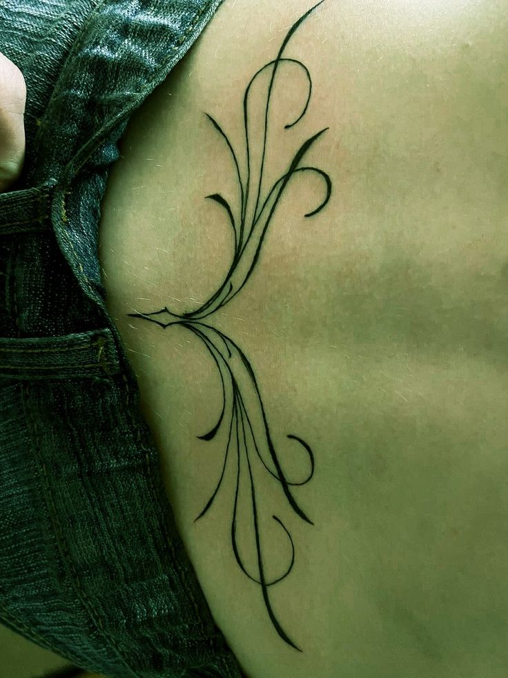 a woman's back with a tattoo on it