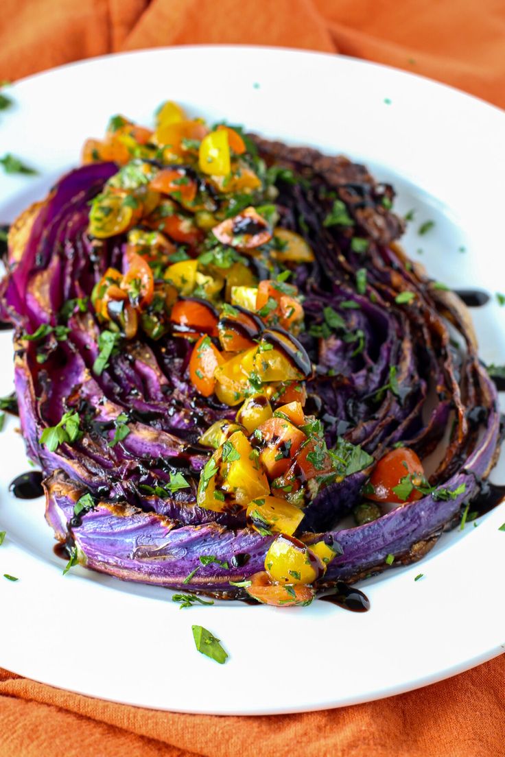 a white plate topped with purple cabbage and tomatoes