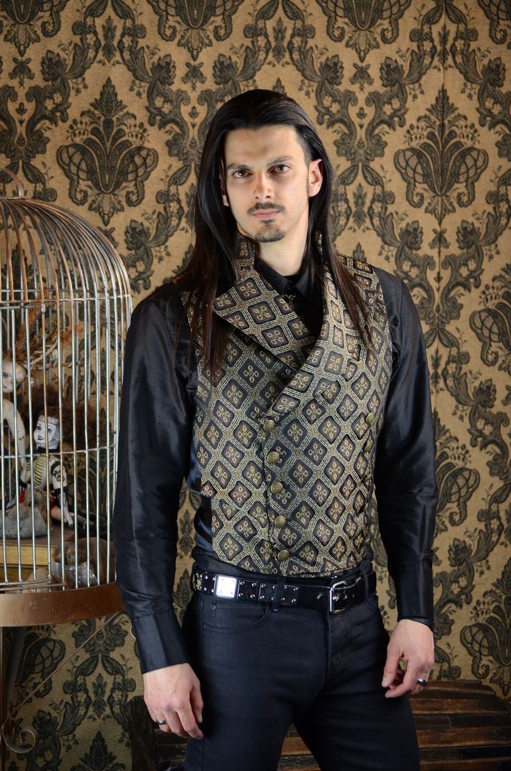 "An elegant double breasted vest for formal occasions. A fitted vest made in rich brown and gold and brocade fabric with a stand up top collar and wide sweeping lapels. Fastens on the inside with a sturdy button and buttons on the outside with five engraved brass buttons. The vest back and inside lining is made from rich black satin. Comes in sizes small-XXL. Wonderful! Measurements: Small: Chest 39\" Stomach 36\" Waist 34\" Medium: Chest 42\" Stomach 38\" Waist 36\" Large: Chest 44\" Stomach 42 Fitted Gold Vest Elegant Style, Gold Fitted Vest, Fitted Gold Elegant Vest, Elegant Gold Fitted Vest, Steampunk Formal Sleeveless Vest, Formal Steampunk Sleeveless Vest, Formal Sleeveless Steampunk Vest, Formal Brown Fitted Nehru Jacket, Fantasy Ball