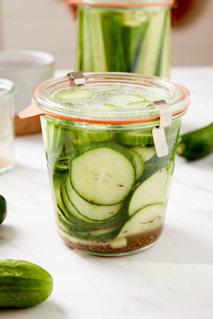 cucumber slices are in a jar on the table