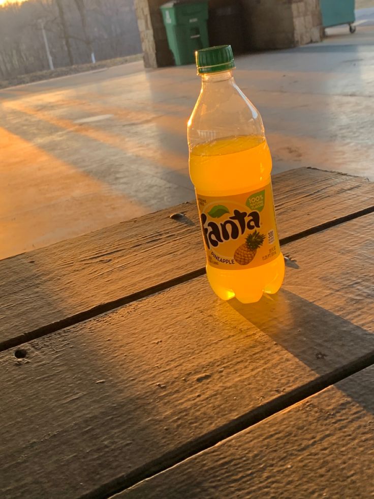 a bottle of soda sitting on top of a wooden table