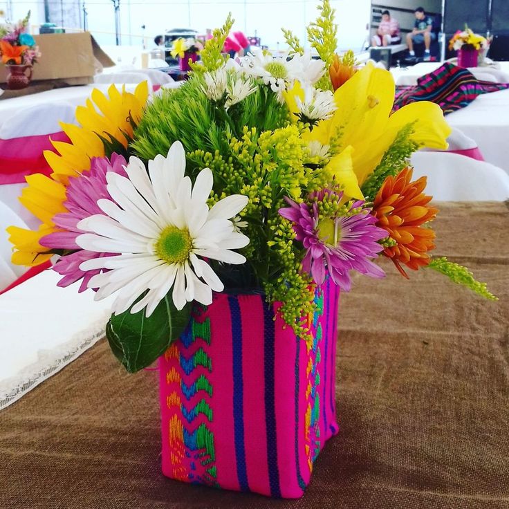 a colorful vase filled with flowers on top of a table